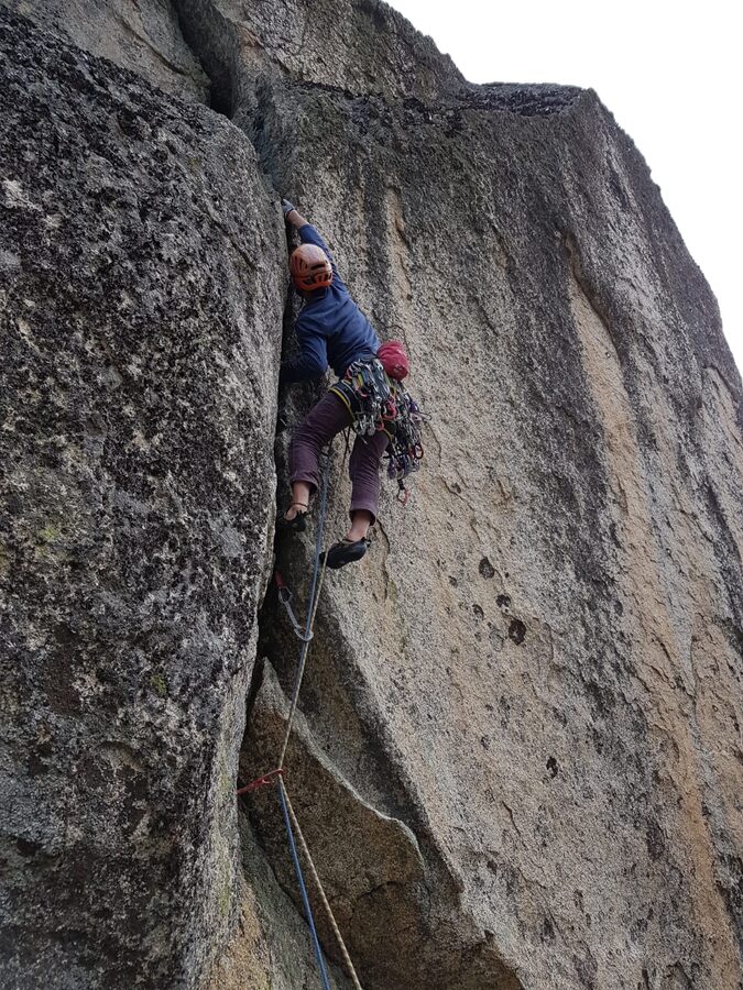 Escalador en una fisura técnica de granito, escalada tradicional